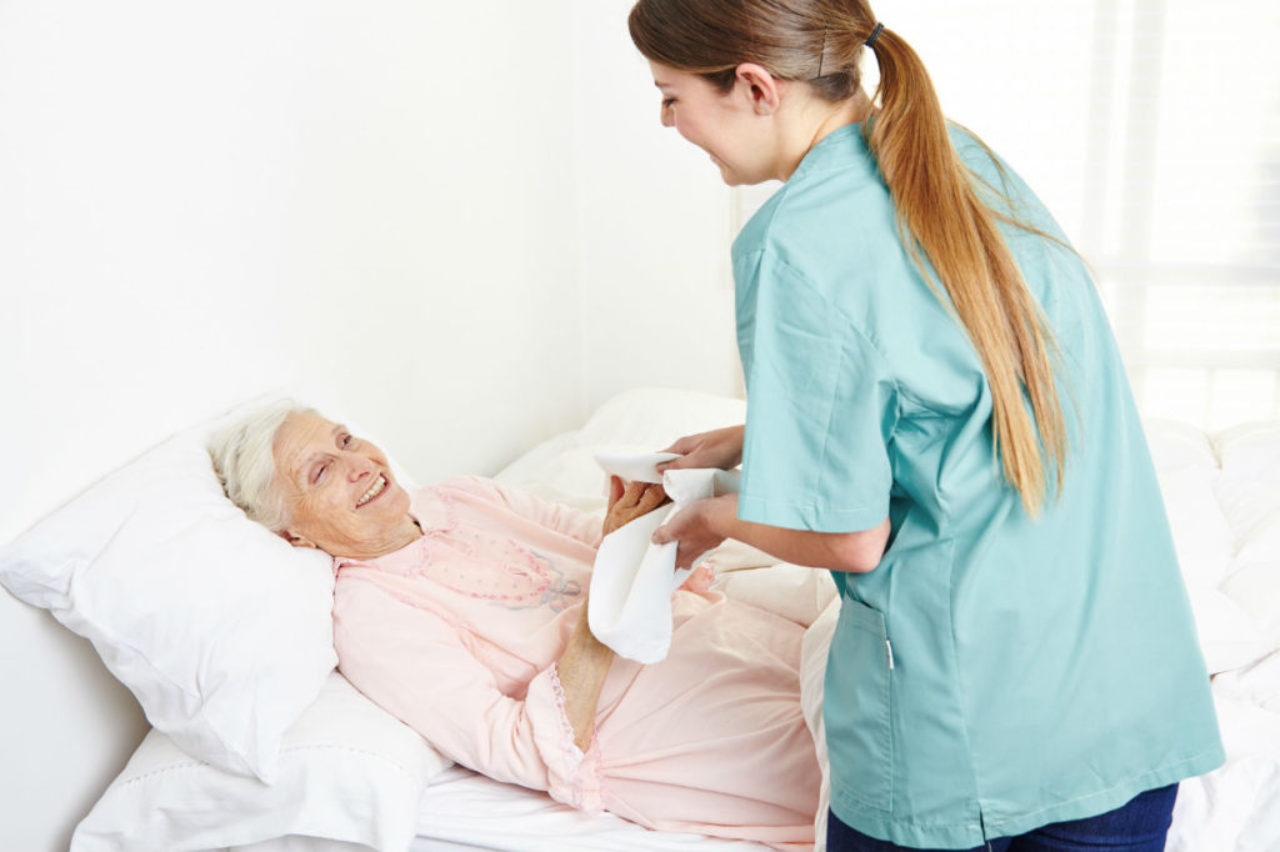 patient-attendant-giveing-towel-bath-to patient-AdobeStock_62053385