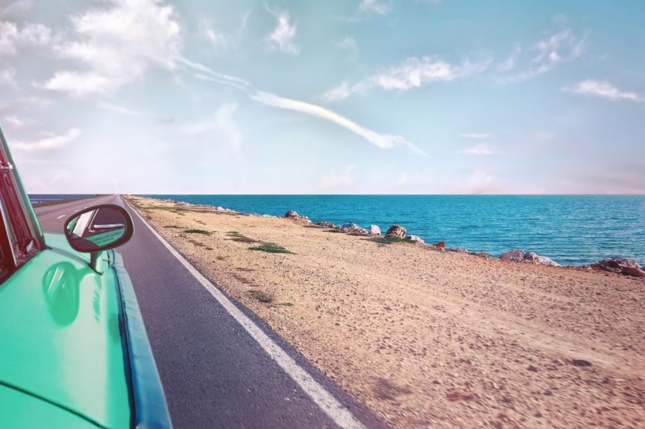 green-car-near-seashore-with-blue-ocean-1118448