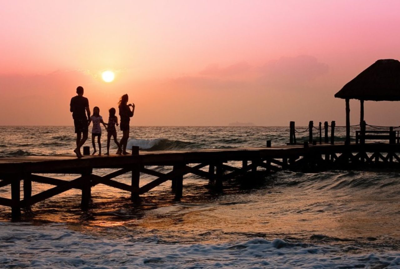 family-on-beach-boardway-at-sunset