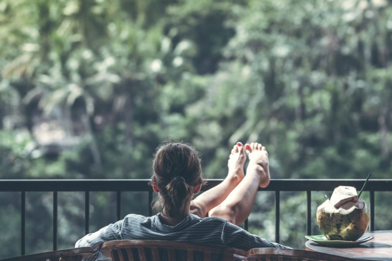 woman-sitting-on-brown-wooden-chair-beside-coconut