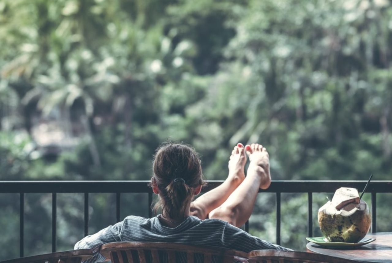 woman-sitting-on-brown-wooden-chair-beside-coconut