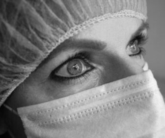 close-picture-of-female-face-wearing-surgical-mask-and-cap-3108660