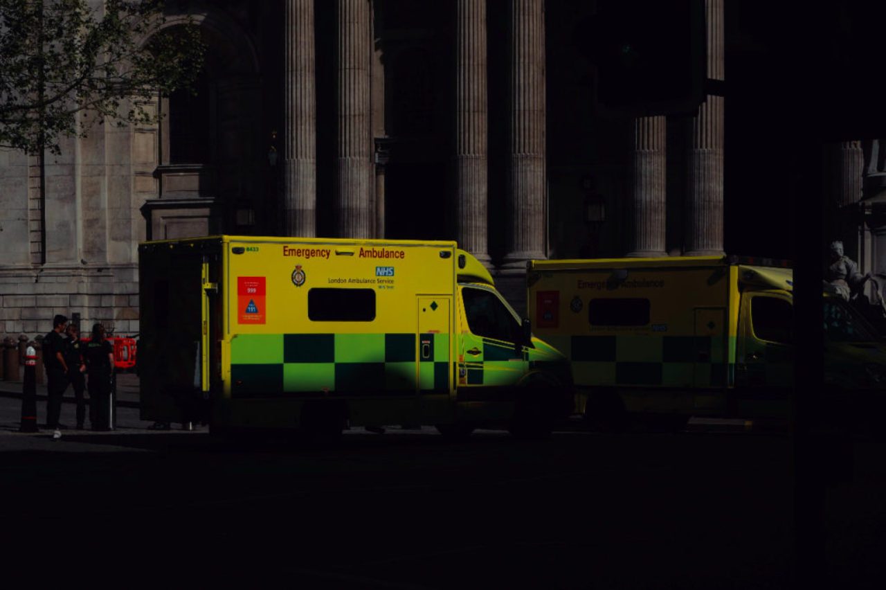 two-ambulances-parked-outside-public-building-sunset