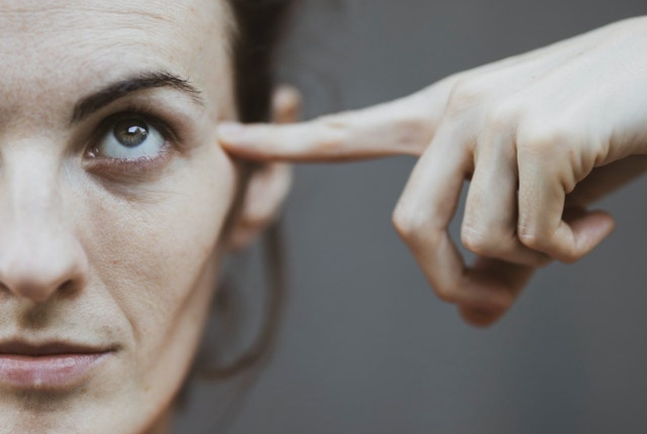 selective-focus-portrait-photo-of-woman-in-red-t-shirt-pointing-to-her-head