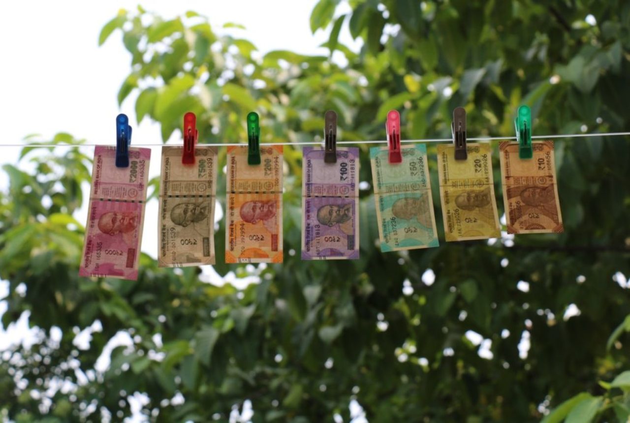 seven-indian-rupee-banknotes-hanging-from-clothesline-on-clothes-pegs