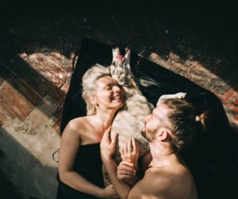 couple-lying-down-and-hugging-their-dog