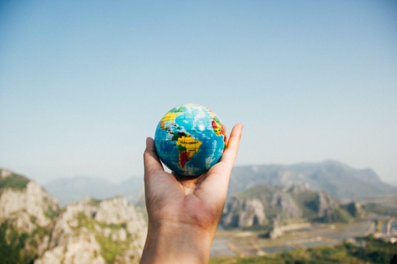 person-holding-world-globe-facing-mountain-346885/